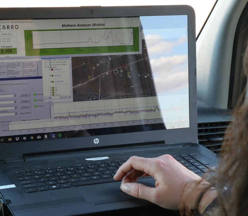 Researcher reviewing data in mobile methane detection vehicle